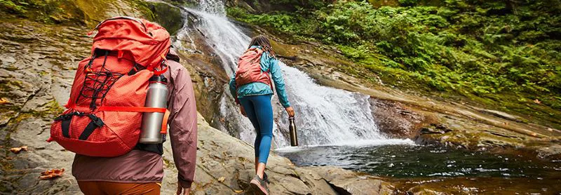 Walkers with Hydro Flasks approaching a waterfall